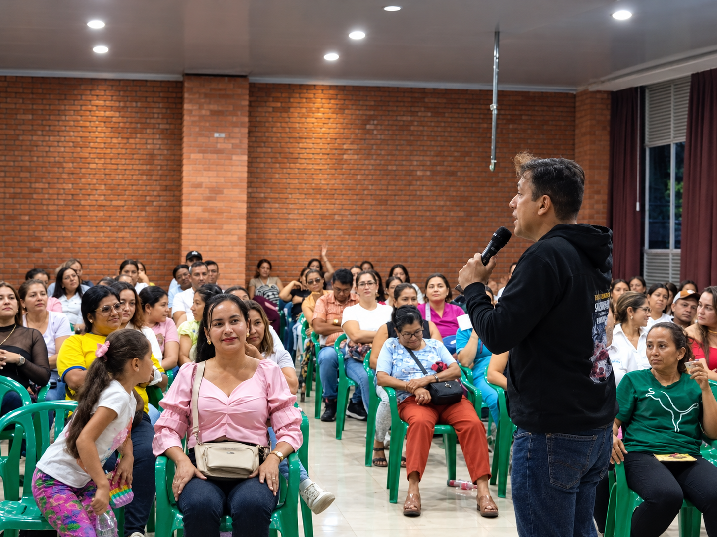 Eduardo Navas guía una charla ante familias en un salón comunitario